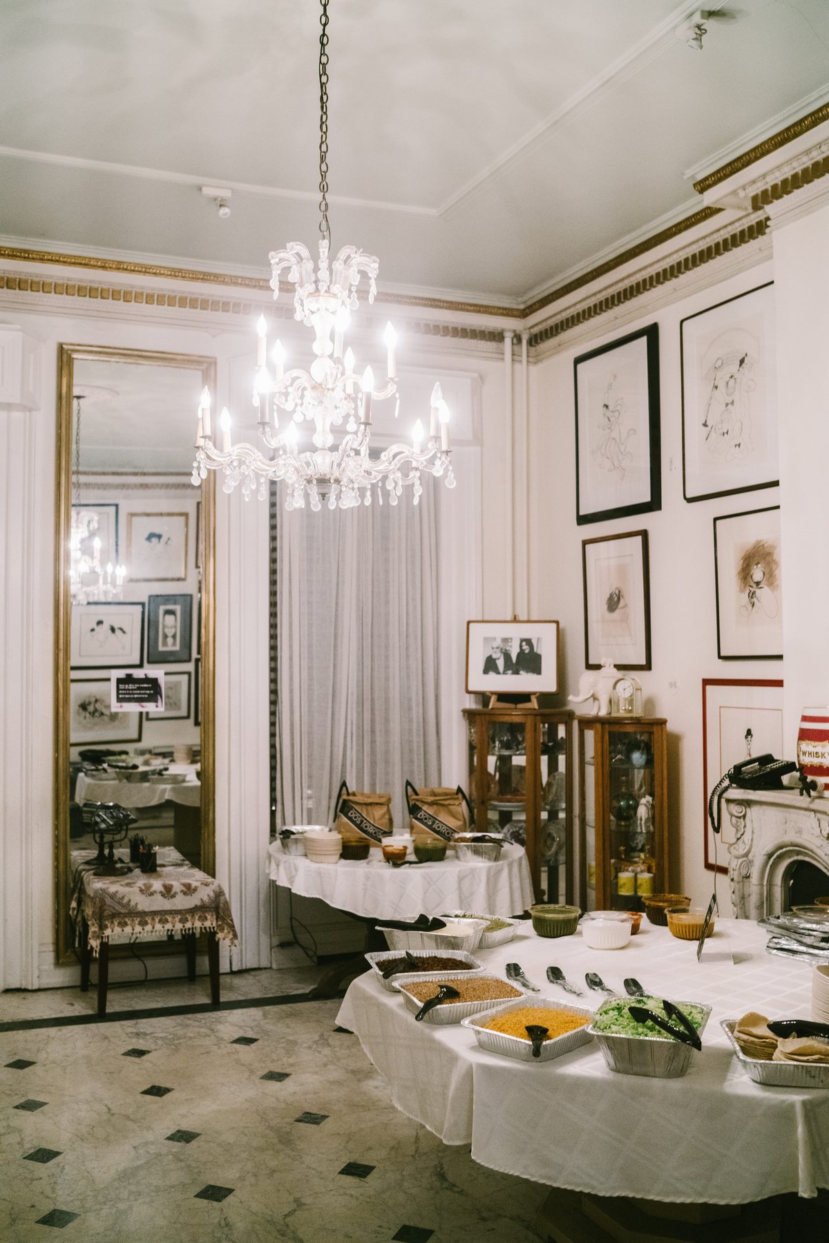 A chandeliered dining room set with a long buffet table