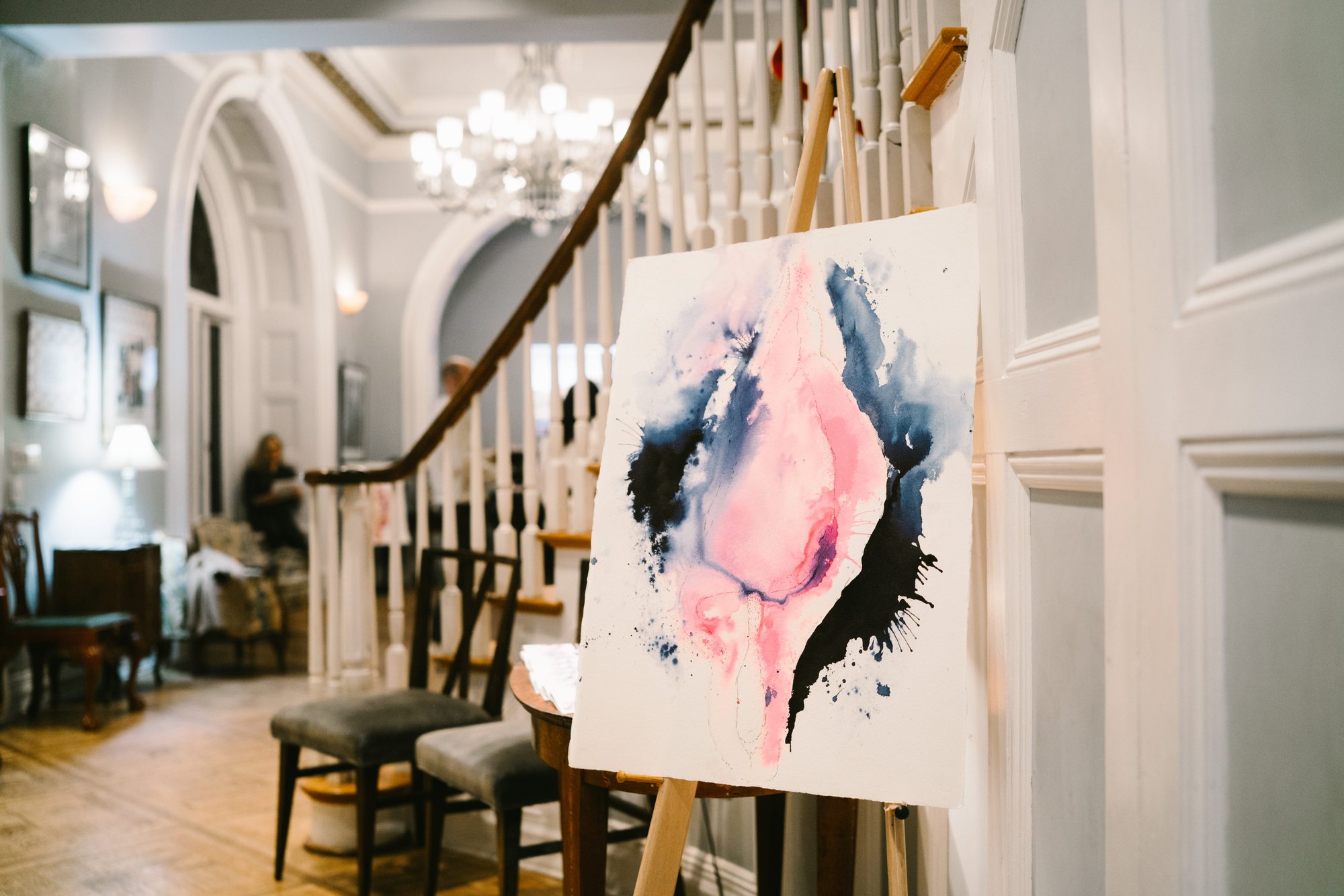 A watercolour painting on an easel in a townhouse hallway
