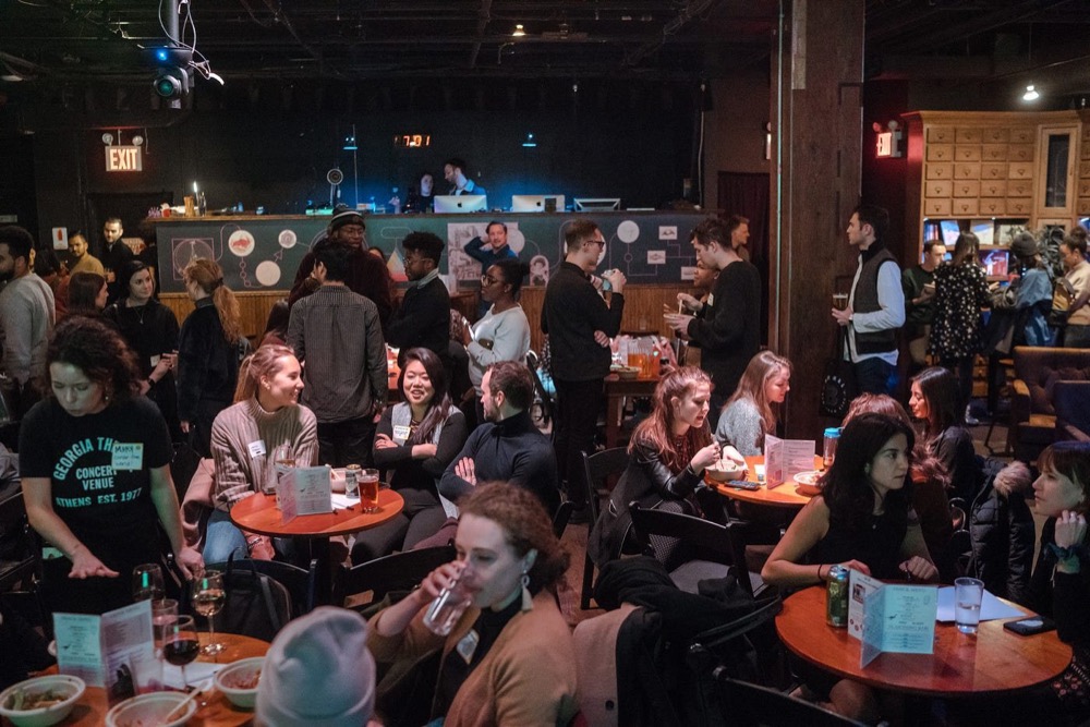 A full bar room of guests at tables at the offtopic townhall