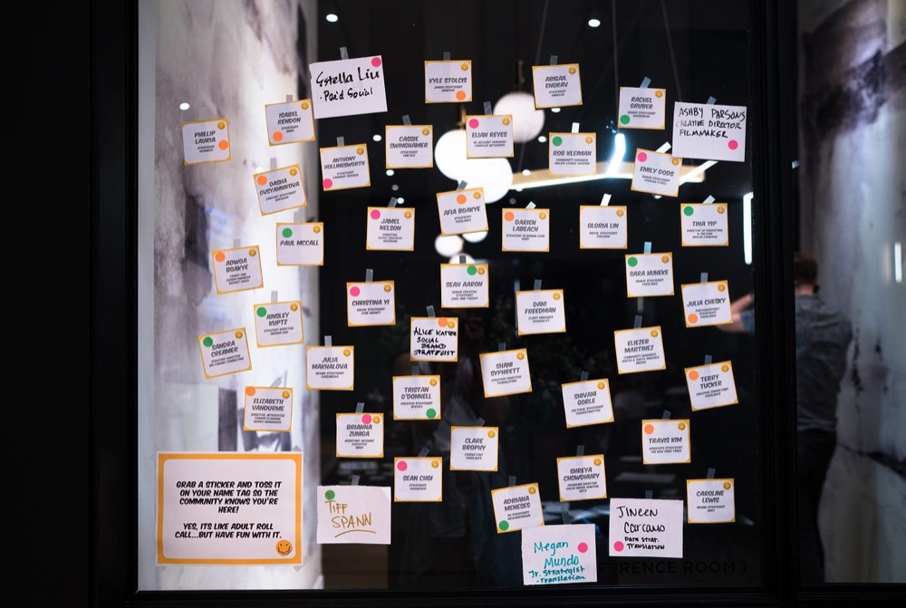 A check-in wall covered in handwritten name cards
