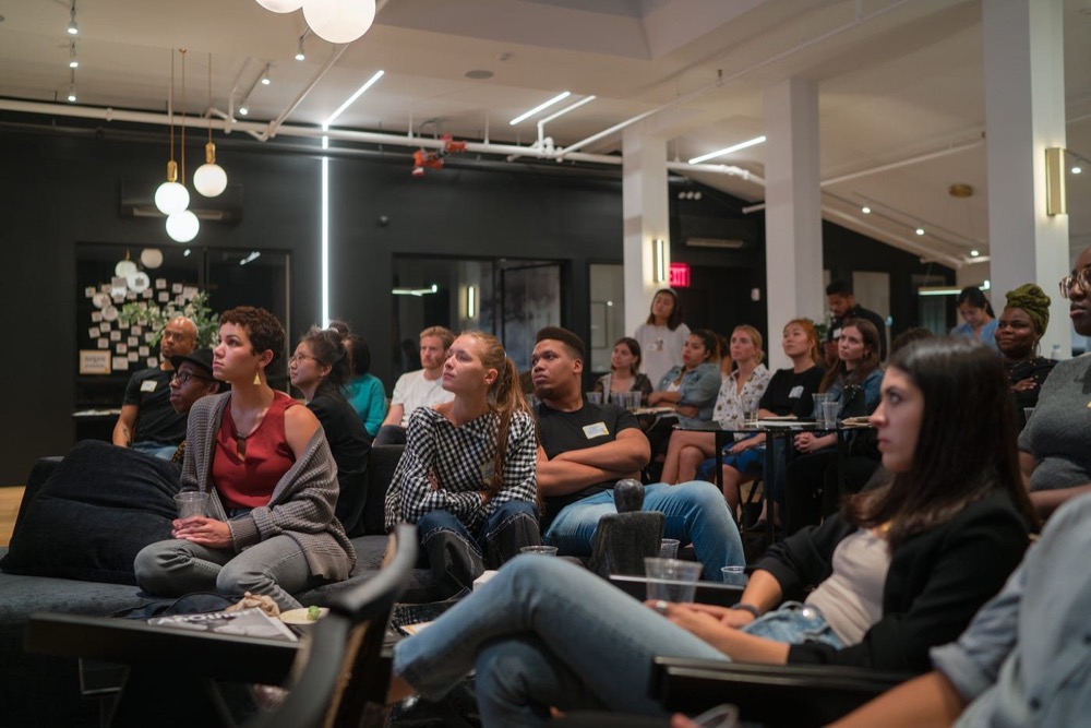 Attendees on sofas listening to a talk